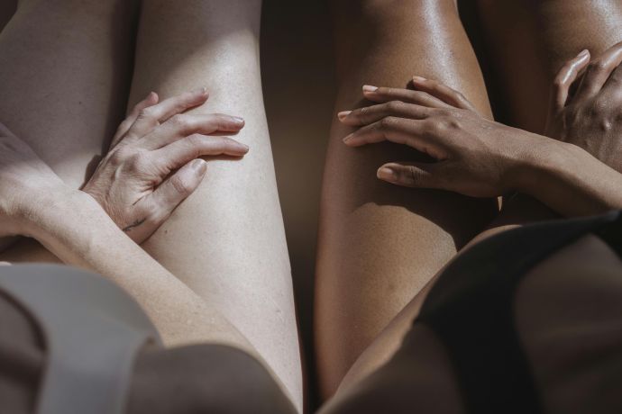 A close-up of diverse women's legs symbolizing unity and individuality indoors.